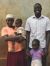 Smiling man with wife and two children