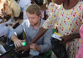 Country Director Joe Huston registers and verifies recipients using palm vein reader