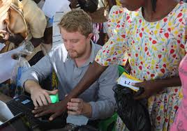 Country Director Joe Huston registers and verifies recipients using palm vein reader