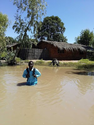 Field officer wading through waist-high water