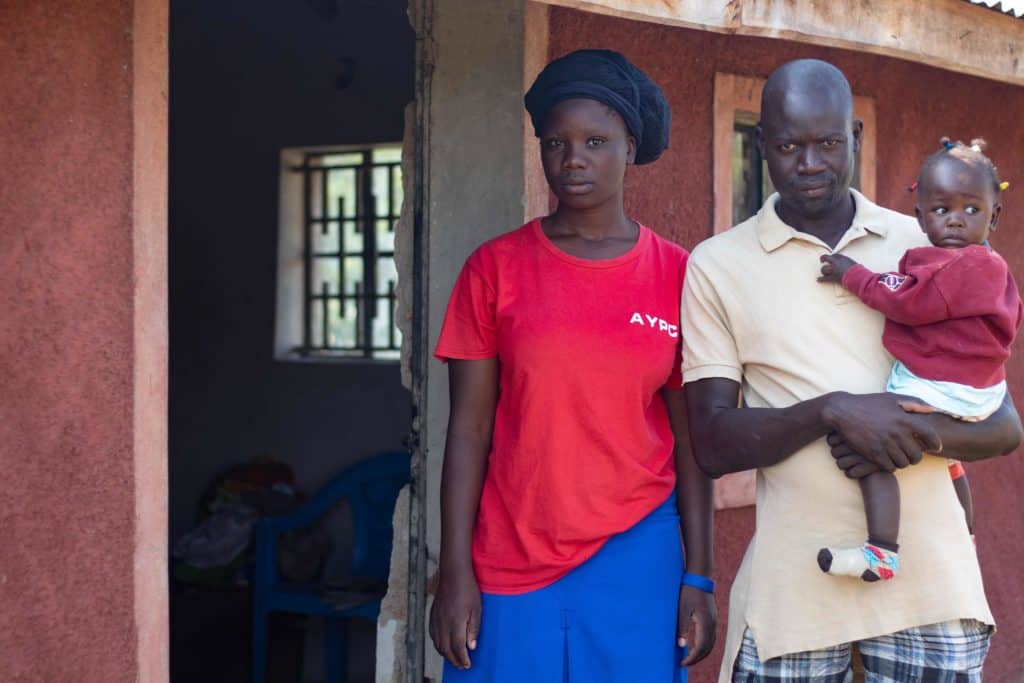 Frederick and Zubeta standing outside their home